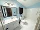 Bathroom with white fixtures, tub, and sink and blue paint at 5846 Par Four Ct, Lithonia, GA 30038