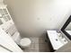 Compact powder room features a pedestal sink, toilet, and a charming wall cabinet for storage at 5846 Par Four Ct, Lithonia, GA 30038