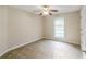 This bedroom features neutral walls, a ceiling fan, and a bright window for natural light at 1451 Brays Mill Trce, Lawrenceville, GA 30044