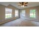 Spacious bedroom with neutral walls, three windows for natural light, and a ceiling fan at 1451 Brays Mill Trce, Lawrenceville, GA 30044
