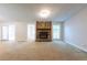 Cozy living room with stone fireplace, carpet flooring, and access to the backyard through sliding glass doors at 1451 Brays Mill Trce, Lawrenceville, GA 30044