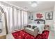 Bedroom features a plush red rug and a statement mirror, alongside tree-themed wall art at 976 Memorial Se Walk, Atlanta, GA 30316