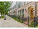 Charming townhomes with brick facade, arched entryways, and black wrought iron fences along a tree-lined street at 976 Memorial Se Walk, Atlanta, GA 30316