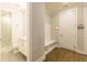 Modern mudroom featuring tile floors, a built-in bench, and a view into a bright bathroom at 976 Memorial Se Walk, Atlanta, GA 30316