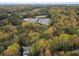 Aerial shot of a leafy neighborhood featuring homes surrounded by fall foliage and nearby buildings at 1153 Dawn View Nw Ln, Atlanta, GA 30327