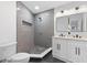 Modern bathroom featuring a walk-in shower with gray tiling and a double vanity with white cabinetry and black hardware at 1153 Dawn View Nw Ln, Atlanta, GA 30327