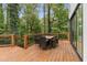 Beautiful outdoor deck space with wood flooring, a table and chairs, and a view of the trees at 1153 Dawn View Nw Ln, Atlanta, GA 30327