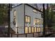 Modern home with large windows, exterior lighting, and a deck, nestled amongst mature trees at 1153 Dawn View Nw Ln, Atlanta, GA 30327