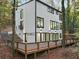 Modern home with large windows, exterior lighting, and a deck, nestled amongst mature trees at 1153 Dawn View Nw Ln, Atlanta, GA 30327