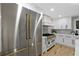 The kitchen features a stainless steel refrigerator, white cabinets and oven range with gold trim at 1153 Dawn View Nw Ln, Atlanta, GA 30327