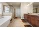Luxurious primary bathroom featuring a soaking tub, walk-in shower, double vanity, and tiled floors at 2212 Nichols Valley Drive, Dacula, GA 30019