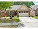 Charming brick home with a two-car garage, a well-manicured lawn and mature landscaping at 2212 Nichols Valley Drive, Dacula, GA 30019