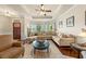 Open-concept living room with large sectional, hardwood floors and access to entryway and dining area at 2212 Nichols Valley Drive, Dacula, GA 30019