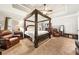 Spacious main bedroom suite with a four-poster bed, sitting area, and coffered ceiling at 2212 Nichols Valley Drive, Dacula, GA 30019