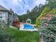 In-ground pool, with a gazebo, deck, and beautiful landscaping creating a serene backyard oasis at 302 Gilmer Ct, Canton, GA 30115