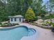 Inviting in-ground pool complemented by a charming pool house and landscaped rock features at 302 Gilmer Ct, Canton, GA 30115
