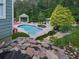 Lush backyard featuring an in-ground pool, gazebo, rock features and manicured landscaping at 302 Gilmer Ct, Canton, GA 30115