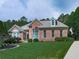 Beautiful brick home with a well-maintained lawn, mature trees, and traditional design elements at 302 Gilmer Ct, Canton, GA 30115