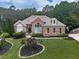 Charming brick home featuring manicured lawn, lush landscaping, and classic architectural details at 302 Gilmer Ct, Canton, GA 30115