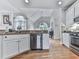 Well-lit kitchen with stainless steel appliances, white cabinetry, hardwood floors, and plenty of counter space at 302 Gilmer Ct, Canton, GA 30115