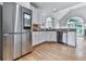Contemporary kitchen with stainless steel refrigerator, white cabinets, hardwood floors, and modern appliances at 302 Gilmer Ct, Canton, GA 30115