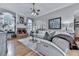 Inviting living room with a cozy fireplace, hardwood floors, large windows, and stylish white furniture at 302 Gilmer Ct, Canton, GA 30115