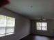 A well-lit living room with dark wood floors, two windows with white blinds, and a ceiling fan at 3242 Cascade Parc Sw Blvd, Atlanta, GA 30311