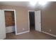 Bedroom with tan carpet, two doors and a closet at 5927 Sherrie Ln, Powder Springs, GA 30127