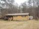 Exterior of a house with brown siding and storage building in back at 5927 Sherrie Ln, Powder Springs, GA 30127