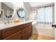 Bright bathroom featuring dual sinks, a large mirror, and a soaking tub at 5070 Saddle Bridge Ln, Alpharetta, GA 30022