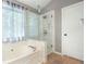 Bright bathroom features a soaking tub and glass enclosed shower at 5070 Saddle Bridge Ln, Alpharetta, GA 30022