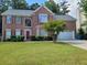 Charming brick home with a well-manicured lawn and a two-car garage, blending traditional elegance and curb appeal at 5070 Saddle Bridge Ln, Alpharetta, GA 30022