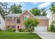 Beautiful brick home with lush greenery, featuring a well-maintained lawn and a welcoming two-car garage at 5070 Saddle Bridge Ln, Alpharetta, GA 30022
