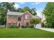 Inviting brick home with red shutters, showcasing a manicured front yard and an attached two-car garage at 5070 Saddle Bridge Ln, Alpharetta, GA 30022