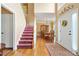 Elegant foyer with hardwood floors, a staircase with patterned runner, and views of the formal dining room at 5070 Saddle Bridge Ln, Alpharetta, GA 30022