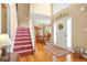 Grand foyer with hardwood floors, open staircase, and a view into the formal dining area with chandelier at 5070 Saddle Bridge Ln, Alpharetta, GA 30022