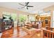 Comfortable living room featuring hardwood floors and modern ceiling fan open to kitchen at 5070 Saddle Bridge Ln, Alpharetta, GA 30022