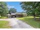 Charming single-story home featuring a gravel driveway and mature trees and covered parking at 578 Laney Rd, Locust Grove, GA 30248