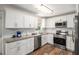 Modern kitchen with stainless steel appliances, granite countertops, and white cabinets at 578 Laney Rd, Locust Grove, GA 30248