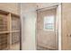 Tiled shower featuring glass door, built-in shelving, and a window for natural light at 578 Laney Rd, Locust Grove, GA 30248