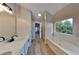 Bright bathroom featuring a garden tub under a window and double vanity for a comfortable and relaxing experience at 6170 Winston Trce, Mcdonough, GA 30252