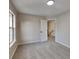 Bright bedroom featuring neutral carpet and paint, a large window, and a view of the hallway at 6170 Winston Trce, Mcdonough, GA 30252