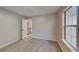 Bright bedroom featuring neutral carpet and paint, a large window, and an open doorway to the hallway at 6170 Winston Trce, Mcdonough, GA 30252