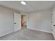 Comfortable bedroom with neutral carpet and paint, a large window, and an open doorway to the hallway at 6170 Winston Trce, Mcdonough, GA 30252