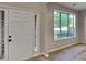 Bright foyer with hardwood floors, a large window, and a six-panel front door at 6170 Winston Trce, Mcdonough, GA 30252