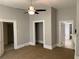 Spacious bedroom with neutral walls, carpet, ceiling fan, and multiple doorways at 1234 Triple Hill Dr, Macon, GA 30084