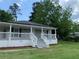 Inviting home showcasing a covered front porch with white railings and steps at 1234 Triple Hill Dr, Macon, GA 30084