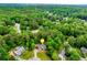 Overhead shot showcasing a neighborhood nestled amidst lush trees, highlighting the house with a marker at 3982 Ivory Gables Pl, Buford, GA 30519