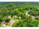 Aerial view displays house surrounded by verdant treetops, complete with a map marker for easy identification at 3982 Ivory Gables Pl, Buford, GA 30519