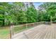 Wooden deck overlooking lush green foliage and featuring wooden railings at 3982 Ivory Gables Pl, Buford, GA 30519